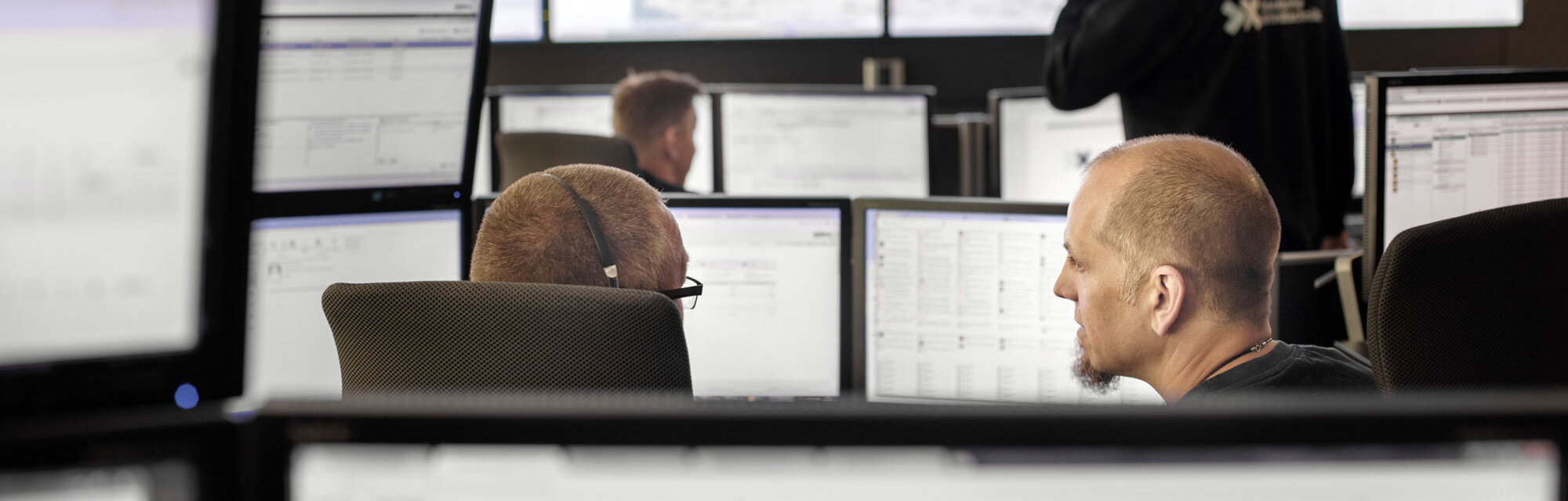 Personen in der Serviceleitwarte überwachen Daten von Windenergieanlagen