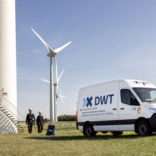 Servicevan neben zwei Servicetechniker*innen und einer Windenergieanlage onshore